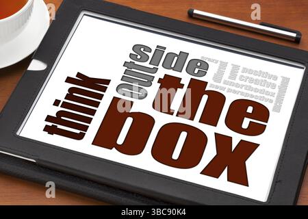 Pensez en dehors du concept de boîte sur une tablette numérique avec tasse de thé Banque D'Images