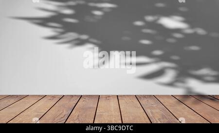 ombre des arbres se balançant doucement dans la brise, sur un fond blanc avec une table en bois. Banque D'Images