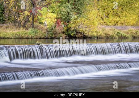Au cours d'une cascade d'eau sur le barrage de dérivation de la rivière Powder avec couleurs d'automne au bakcground Banque D'Images