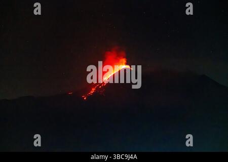 Éruption nocturne avec des ruisseaux de lave brillants Banque D'Images