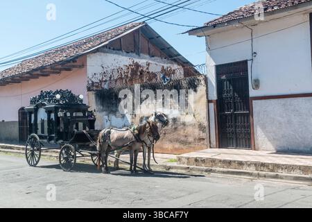 Cheval antique tiré corbillard attendant en préparation pour des funérailles dans une rue devant une organisation funéraire. Grenade, Nicaragua. Banque D'Images