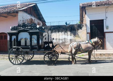 Cheval antique tiré corbillard attendant en préparation pour des funérailles dans une rue devant une organisation funéraire. Grenade, Nicaragua. Banque D'Images