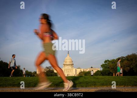Washington DC, Vereinigte Staaten. 24 avril 2025. Une femme court devant le Capitole des États-Unis dans le soleil du soir à Washington DC, le 24 avril 2025. Crédit : dpa/Alamy Live News Banque D'Images