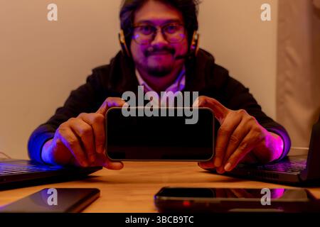 Découvrez ceci, Un gamer partage avec enthousiasme son écran de jeu mobile avec des amis Banque D'Images