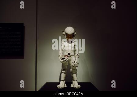 Entraîneur de Pokémon futuriste en armure de porcelaine tient une Poké Ball avec une intensité tranquille à l'exposition Pokémon × Kogei Banque D'Images