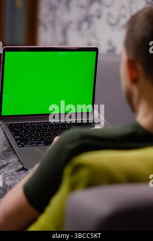 Londres, Royaume-Uni - 12 janvier 2022. Un homme caucasien utilise MacBook Air M1. La personne travaille sur le dernier ordinateur portable Apple avec écran vert de maquette chromakey. Vert Banque D'Images