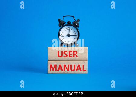 Symbole du manuel de l'utilisateur. Mots conceptuels Manuel de l'utilisateur sur blocs de bois. Beau fond bleu avec réveil. Concept du manuel d'utilisation et de l'entreprise. Copier spa Banque D'Images