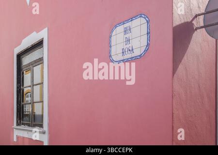 Mur rose avec panneau de rue en céramique bleue Rua da Rosa et réflexion de fenêtre. Architecture traditionnelle portugaise dans le quartier historique d'Angra do He Banque D'Images
