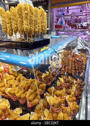 Barcelone Catalogne Espagne. 10 avril 2025. Scènes du marché de la Boqueria avec des expositions vibrantes de tapas au jambon séché, encas frits, roulés de viande et loc Banque D'Images