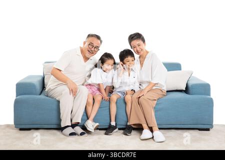 quatre générations (grands-parents et petits-enfants) sur le canapé faisant des appels téléphoniques Banque D'Images