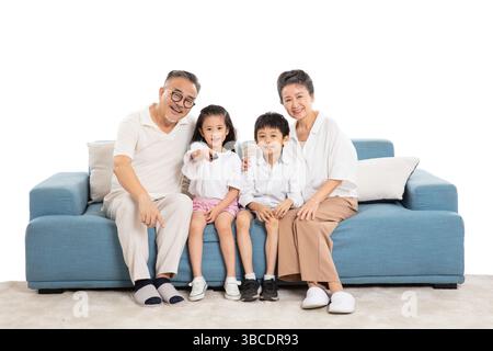 Quatre générations (grands-parents et petits-enfants) regardant la télévision sur le canapé Banque D'Images