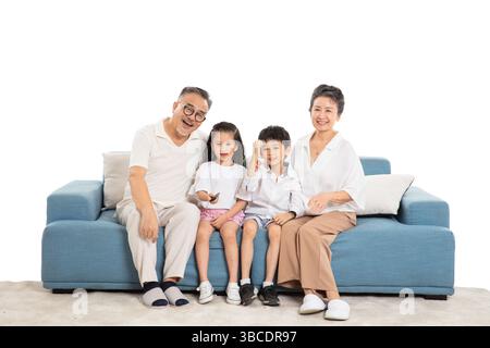 Quatre générations (grands-parents et petits-enfants) regardant la télévision sur le canapé Banque D'Images