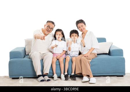 Quatre générations (grands-parents et petits-enfants) regardant la télévision sur le canapé Banque D'Images