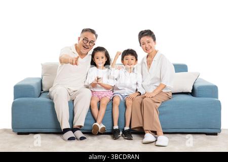 Quatre générations (grands-parents et petits-enfants) regardant la télévision sur le canapé Banque D'Images