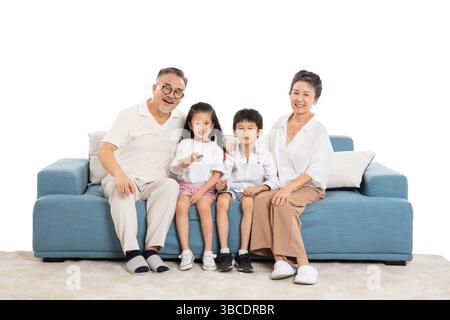 Quatre générations (grands-parents et petits-enfants) regardant la télévision sur le canapé Banque D'Images
