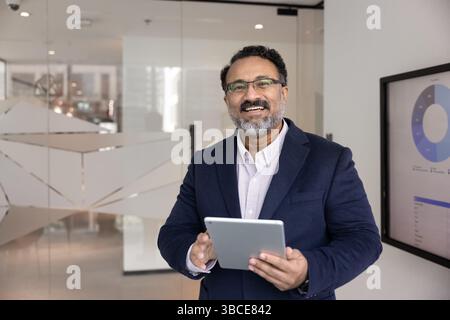 Portrait d'heureux cadre masculin utilisant des outils numériques sur tablette Banque D'Images