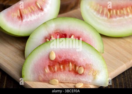 couper la petite pastèque non mûre sur une planche, couper en morceaux pastèque non mûre de petite taille Banque D'Images