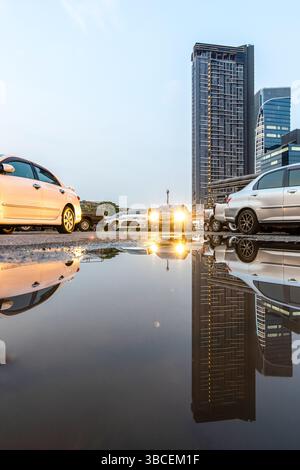 Une voiture passant devant une zone inondée après de fortes pluies dans une ville. Banque D'Images