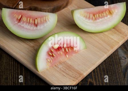 couper la petite pastèque non mûre sur une planche, couper en morceaux pastèque non mûre de petite taille Banque D'Images