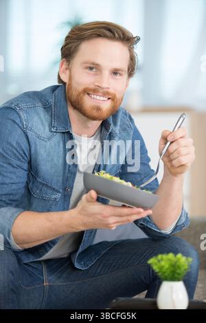 plan d'un beau jeune homme mangeant à la maison Banque D'Images