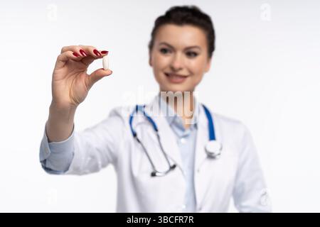 Photo de charmante femme attrayante un thérapeute spécialisé qualifié portent des pilules blanches de tenue de main de robe de médecin isolées sur fond blanc Banque D'Images