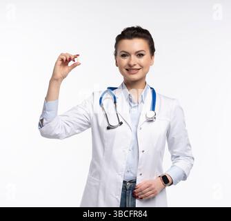 Photo de charmante femme attrayante un thérapeute spécialisé qualifié portent des pilules blanches de tenue de main de robe de médecin isolées sur fond blanc Banque D'Images