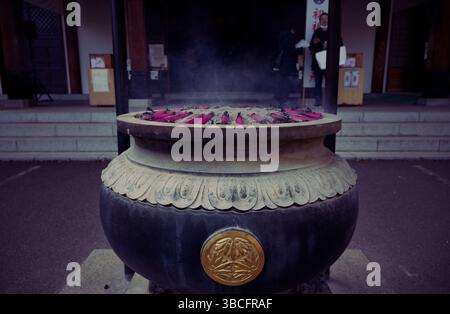 La fumée s'élève doucement d'un brûleur d'encens cérémoniel dans un temple Banque D'Images