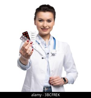 Photo de charmante femme attrayante un thérapeute spécialisé qualifié portent des pilules blanches de tenue de main de robe de médecin isolées sur fond blanc Banque D'Images