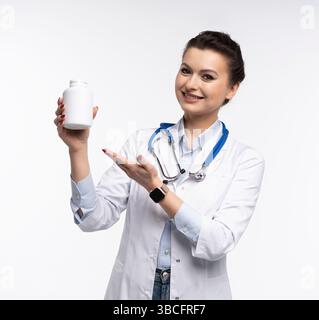 Photo de charmante femme attrayante un thérapeute spécialisé qualifié portent des pilules blanches de tenue de main de robe de médecin isolées sur fond blanc Banque D'Images