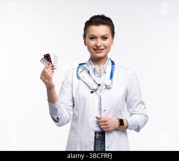 Photo de charmante femme attrayante un thérapeute spécialisé qualifié portent des pilules blanches de tenue de main de robe de médecin isolées sur fond blanc Banque D'Images