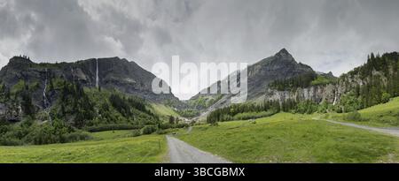 Panorama Mountain paysage avec une forêt luxuriante et plusieurs chutes d'eau dans les Alpes Suisses sous un ciel couvert journée d'été Banque D'Images