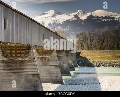 Vieux pont couvert en bois traversant le Rhin à partir de Liechtenstein à la Suisse avec une superbe vue sur les Alpes Suisses au printemps sous un ciel bleu Banque D'Images