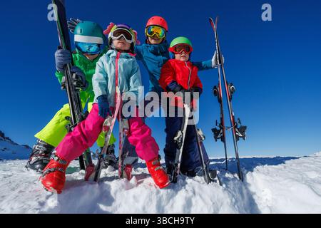 Famille de skieurs heureux avec des enfants pose joyeusement sur les pentes enneigées Banque D'Images