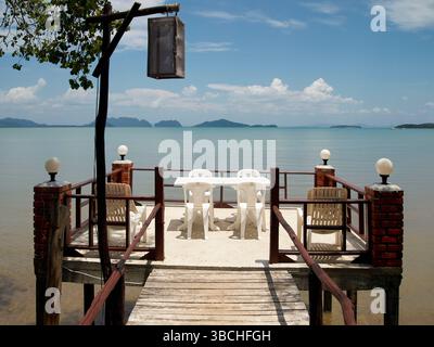 Jetée relaxante en bord de mer avec chaises vides et table donnant sur la vue sur l'océan serein. Thaïlande Banque D'Images