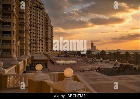 Moody vue sur le coucher du soleil au-dessus de la maison d'appartements à Al Hamra, mer et marine, eau Ras al Khaimah. Banque D'Images