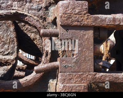 Gros plan de boulons et d'écrous filetés rouillés bruns sur de vieilles machines corrodées Banque D'Images