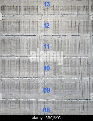 Surface d'un noyau de tour de service en béton d'un bâtiment en construction avec les numéros d'étage marqués en peinture bleue Banque D'Images