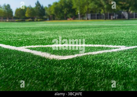 Marquage blanc de coin de terrain de football avec gazon synthétique synthétique artificiel d'herbe verte Banque D'Images