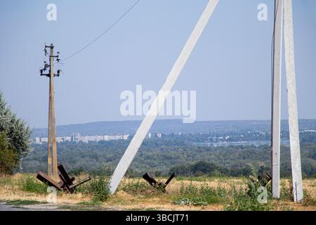 Route, poteaux avec des fils et hérissons anti-chars près de la route sur fond de la ville, guerre en Ukraine, défense de la ville Banque D'Images