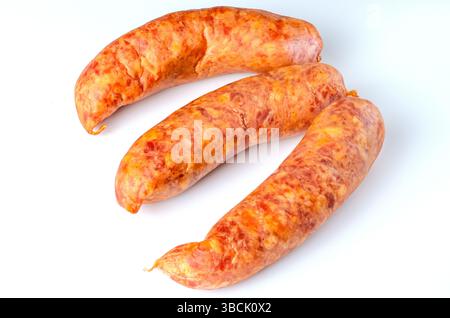 Trois saucisses fumées crues sur fond blanc dans l'éclairage de studio pour l'emballage alimentaire, la publicité et l'usage culinaire Banque D'Images