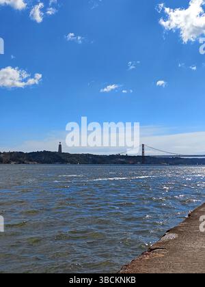 Lisbonne Portugal. Vue panoramique depuis Cais do Sodré montrant le monument Cristo Rei du Tage et le pont suspendu 25 de Abril par une journée ensoleillée Banque D'Images