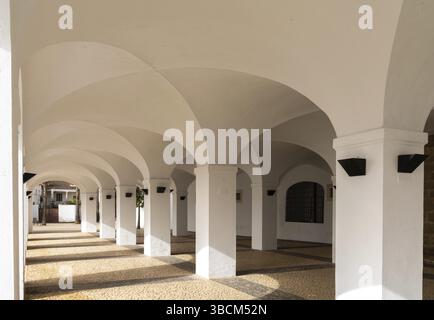 Olivenza, Espagne - 27 mars 2022 : portique blanchi à la chaux avec de nombreuses arches et un sol en pierre à motifs Banque D'Images
