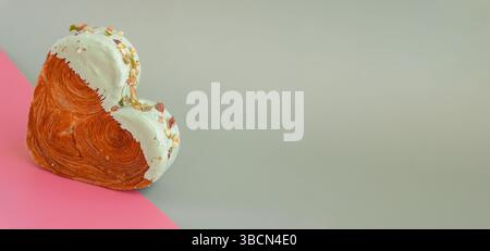 Idée isométrique créative fête de la Saint-Valentin fête des croissants en forme de coeur sur fond de deux couleurs avec espace de copie. Pâte feuilletée nouvelle boulangerie à dessert sucré à la mode. Expérience sur pâte crémeuse Banque D'Images