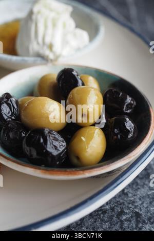 Olives vertes et noires fraîches servies dans un petit bol Banque D'Images