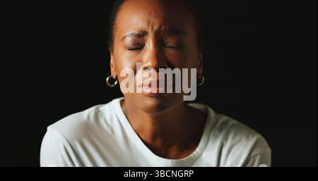 Yeux fermés, femme triste et noire en studio, pleurs et santé mentale sur fond sombre. Personne africaine, espace maquette ou modèle avec larmes, anxiété et Banque D'Images