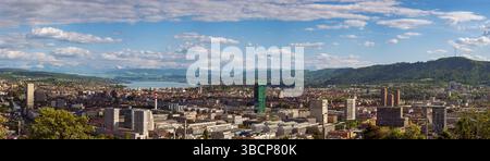 16-05-2025 Zurich, Suisse. Vue panoramique d'en haut comme vu d'un point de vue au sommet d'une colline. Ciel nuageux, Alpes enneigées et lac de Zurich dans le backgrou Banque D'Images