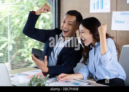 Célébrer le succès en entreprise. Les professionnels visualisent les résultats avec enthousiasme sur une tablette. Banque D'Images