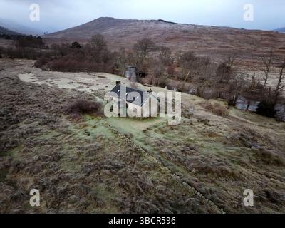 Vue aérienne d'Invermallie Bothy dans les Highlands écossais reculés - un abri de montagne niché à côté d'une rivière sinueuse dans un paysage sauvage et glacial Banque D'Images