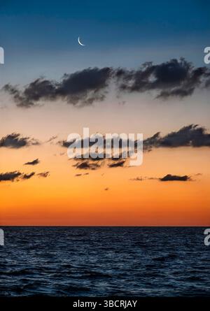 Croissant de lune montant de l'océan Atlantique Banque D'Images