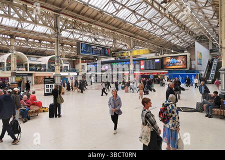 Principal hall réservé aux passagers de la gare Victoria de Londres. Affiche les passagers et les navetteurs et le nouveau tableau d'affichage LED des départs. Banque D'Images